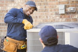 smiling-HVAC-technician-repairing-an-air-conditioner