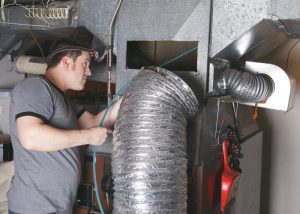 HVAC-technician-cleaning-inside-ducts